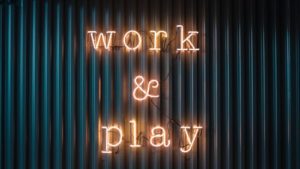 lit up sign on wall that says "Work & Play"