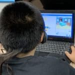 A student using a laptop to create a program in Scratch.