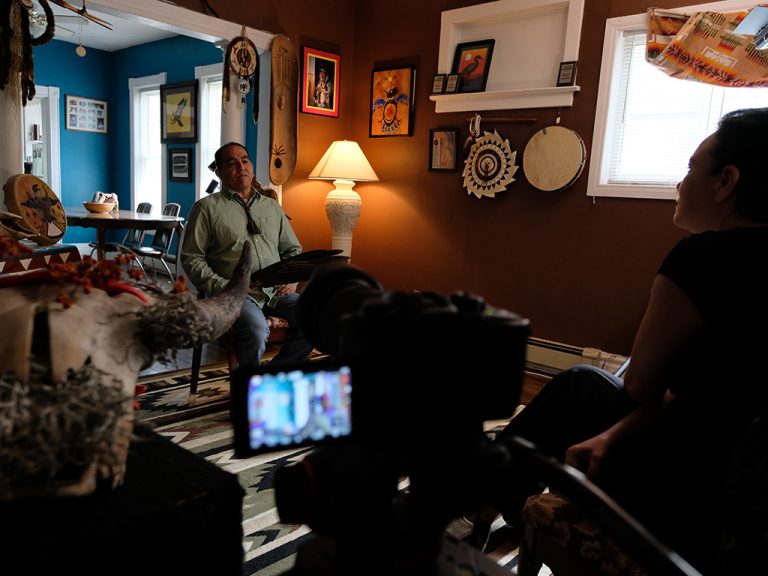 Man being interviewed in front of cameras in a brown room