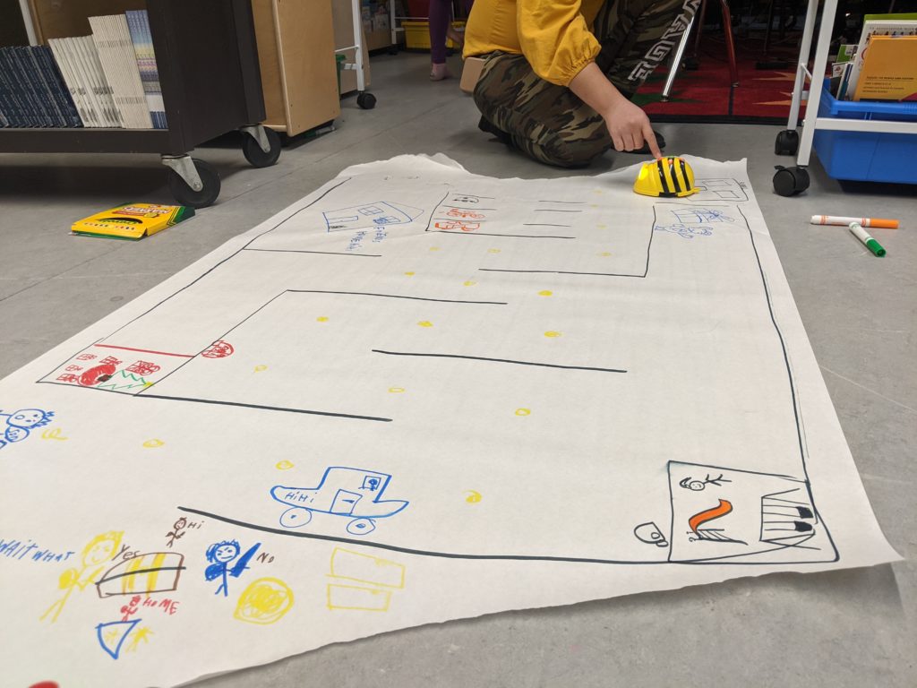 students playing with beebots on a drawn out map