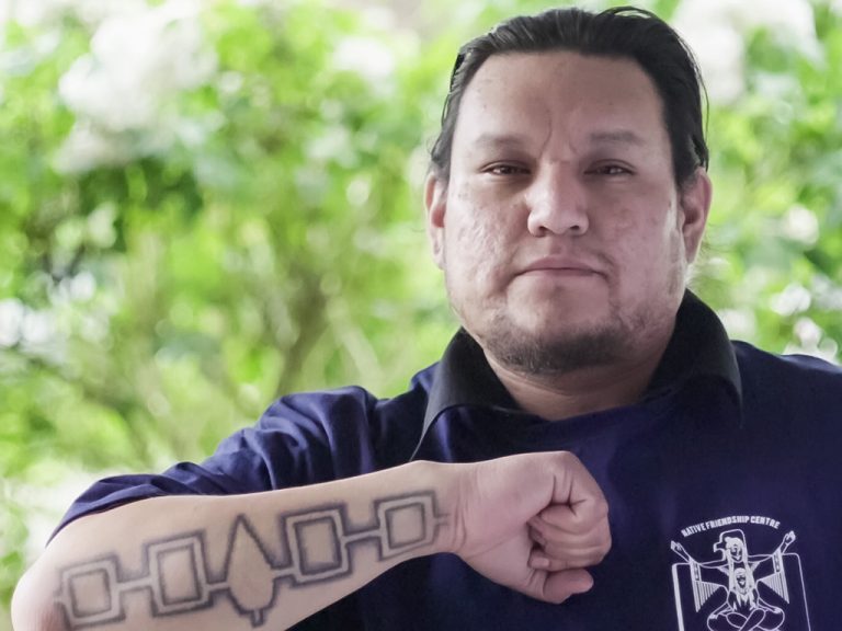 Indigenous man with tattoo on his forearm