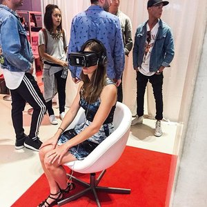 A lady sitting in a white chair with a VR headset on