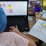 A student creating digital pixel art of a person based on a drawing.