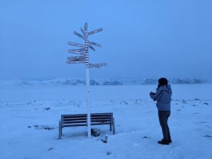 woman standing infront of a post with directions
