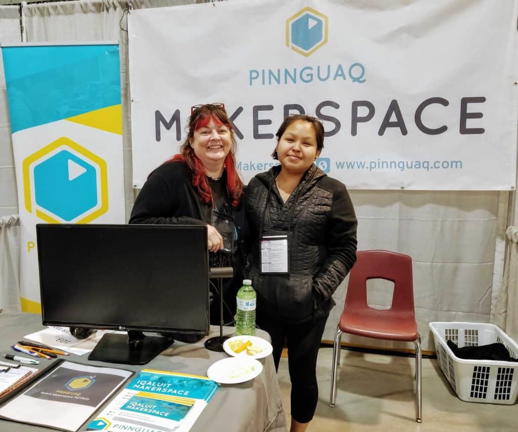 Gail and Talia standing in front of makerspace banner at a convention