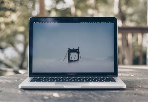 laptop sitting on a desk outside.