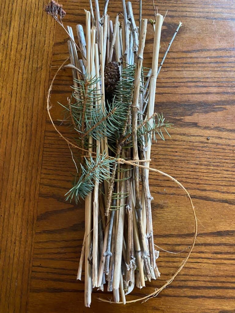 A piece of twine wrapped and tied around the natural materials.