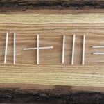 A stick puzzle laying on a wood table.