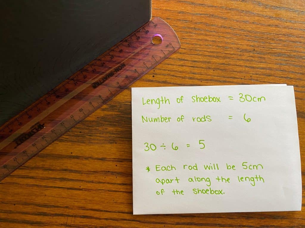 A sheet of paper with information on it laying beside a ruler.