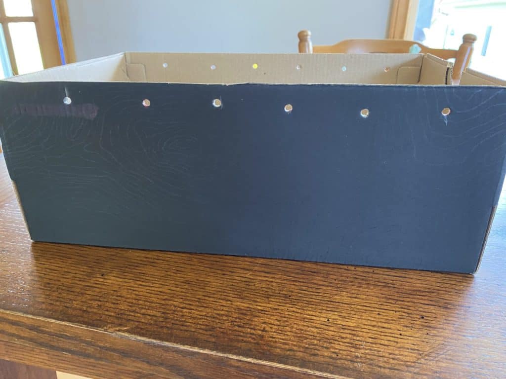 A black box with holds cut into it along the top.