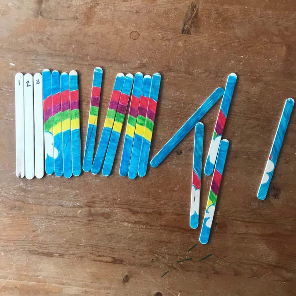 An unfinished rainbow puzzle made with popsicle sticks.