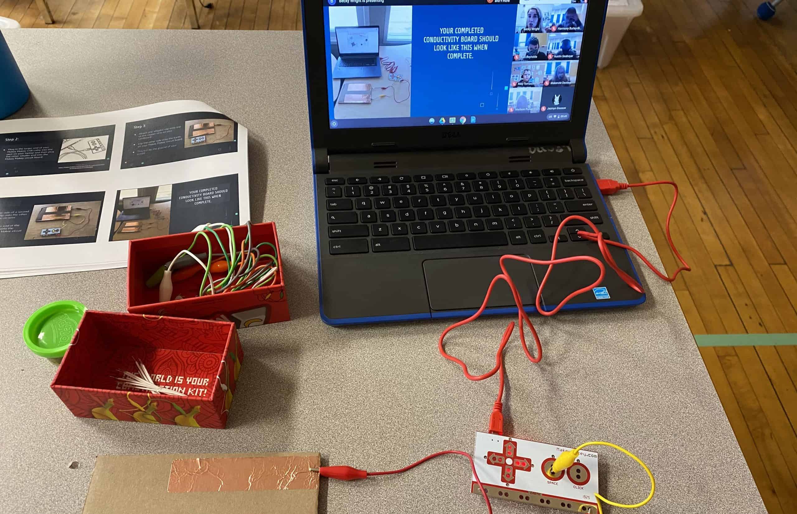 virtually teaching students to build circuits. Their computer is at the top of the screen and they have a makey makey attached to the computer.