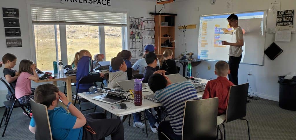 A classroom of students looking towards a whiteboard where staff member Mac Pavia is teaching.