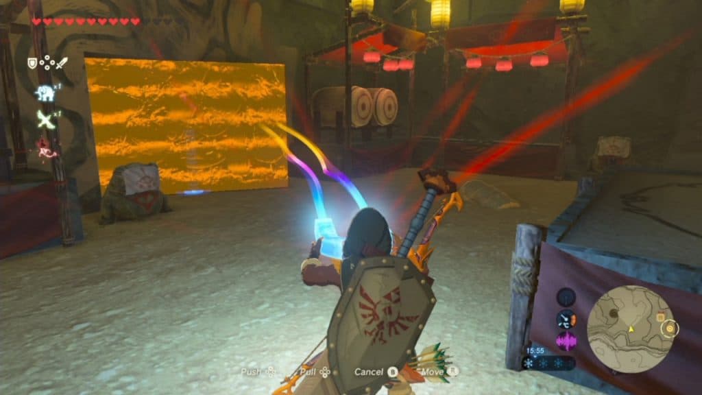 A player using the magnet tool to open a wall behind a treasure in the Yiga Clan hideout in the Zelda Breath of the Wild game.