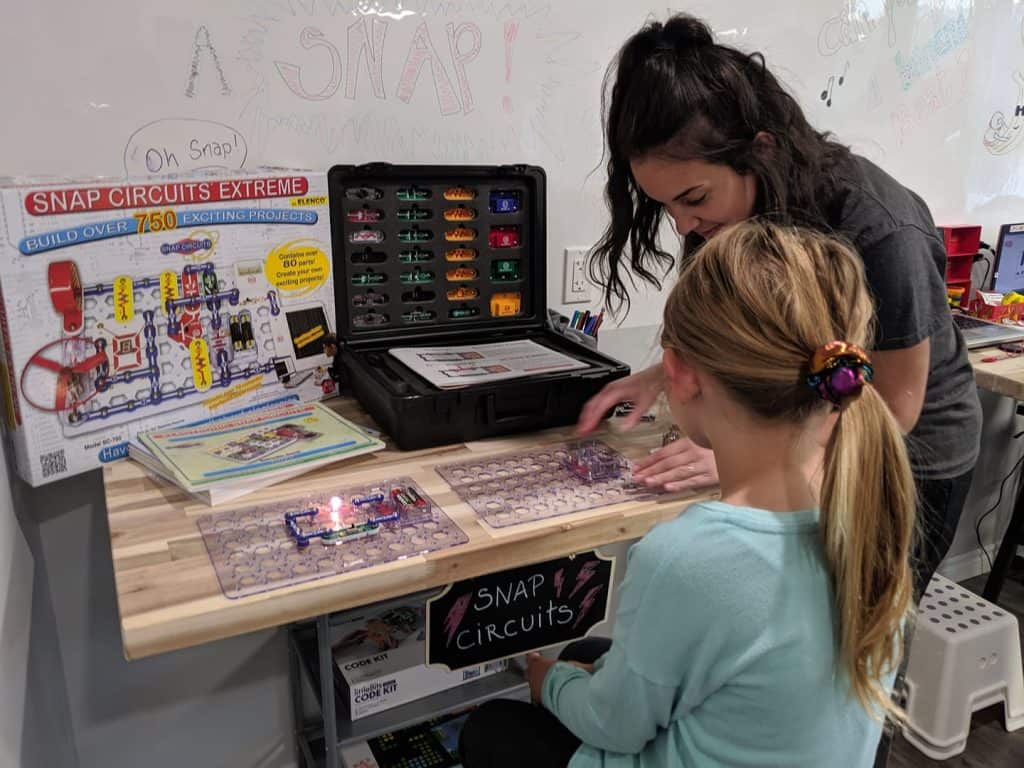Emily in the Makerspace using the the Snap Circuit centre with a student.